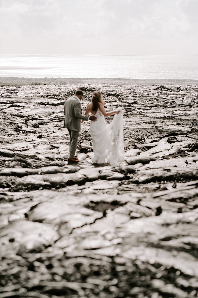 newlyweds walking on a lava field in Hawaii.