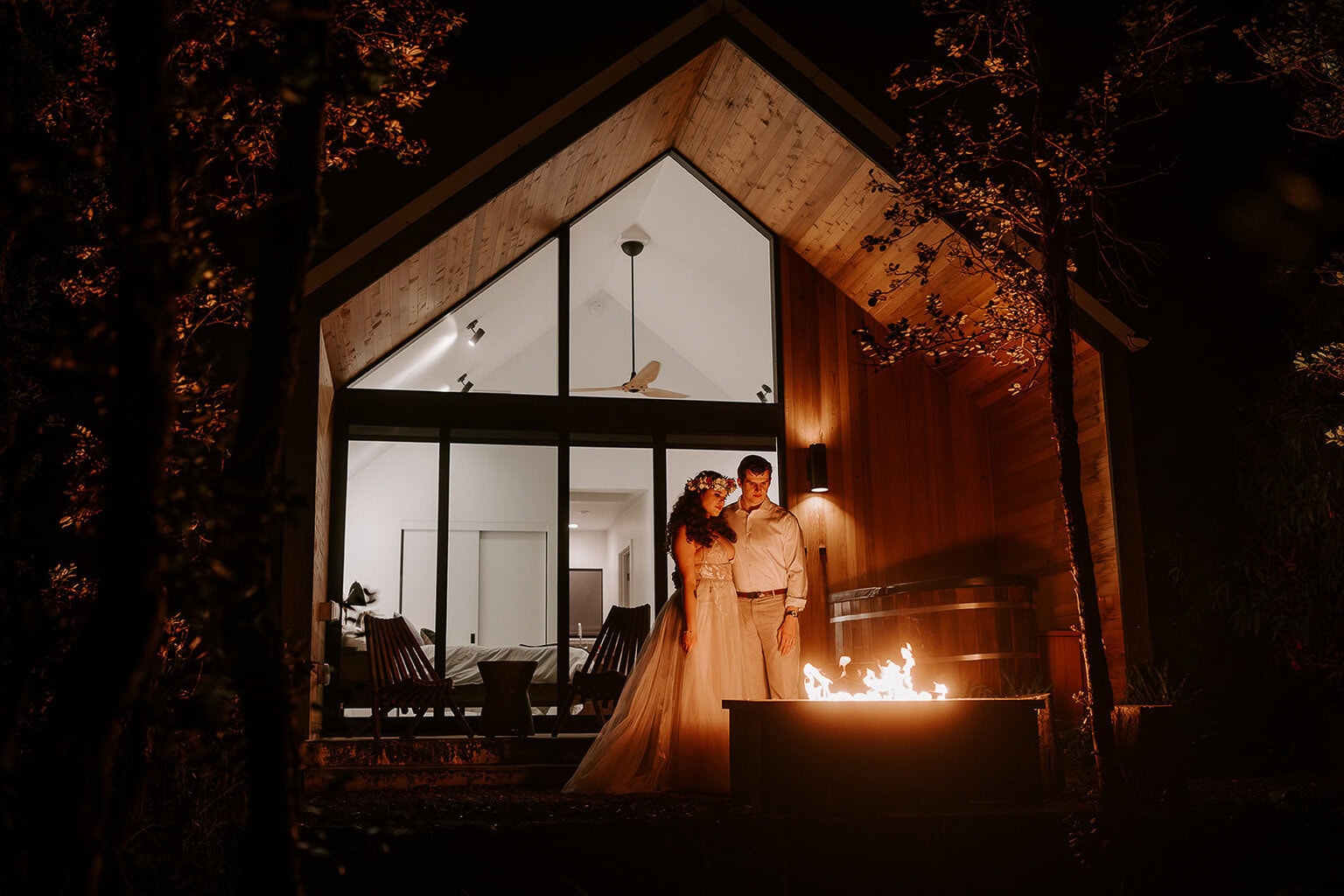 newlyweds staring into a fireplace at a cute airbnb during their Big Island elopement.