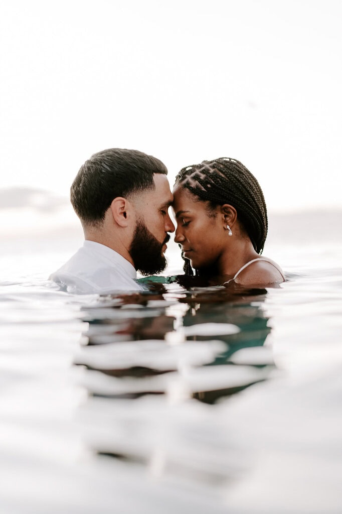 newlyweds hugging while partially under water during their Big Island elopement.
