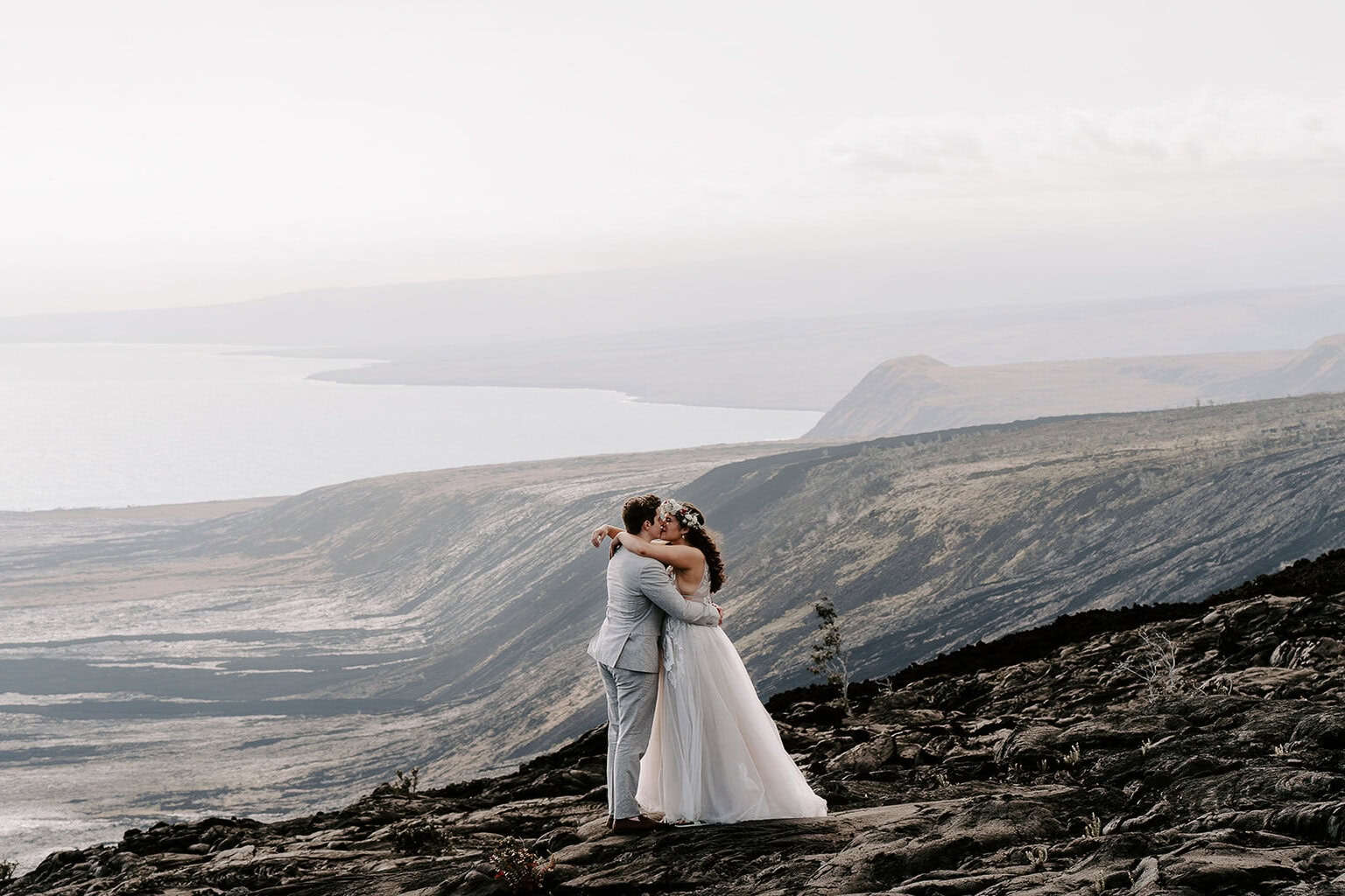 newlyweds kissing on a lava field during their Big Island elopement.