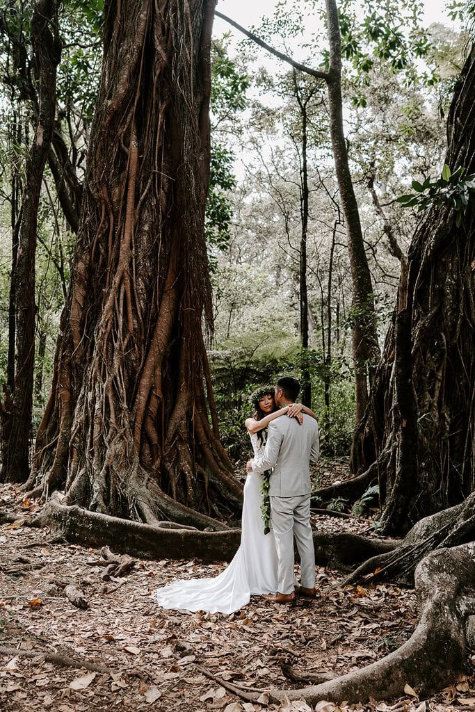 Newlyweds kissing in a Hawaiian jungle during their elopement.
