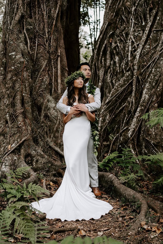 Newlyweds hugging in the jungle as they elope in Hawaii.