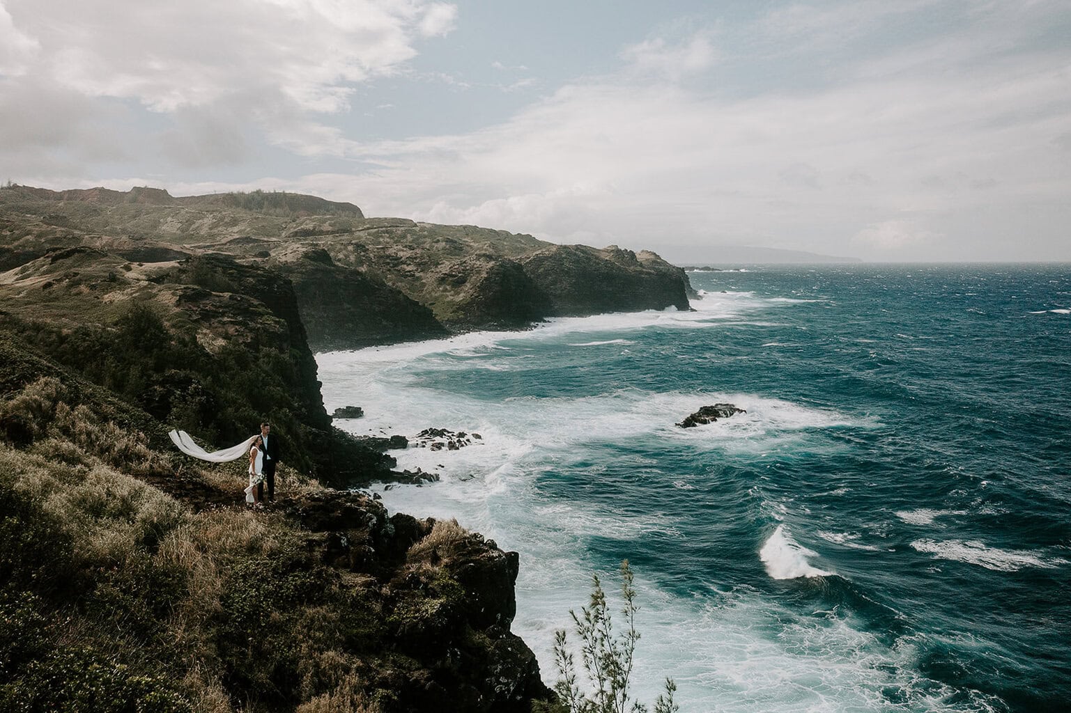 Newlyweds enjoying a cliffside view as they elope in Hawaii.