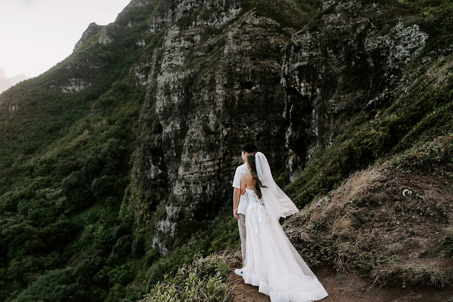 newlyweds enjoying a cliffside view in Oahu as they elope in Hawaii.