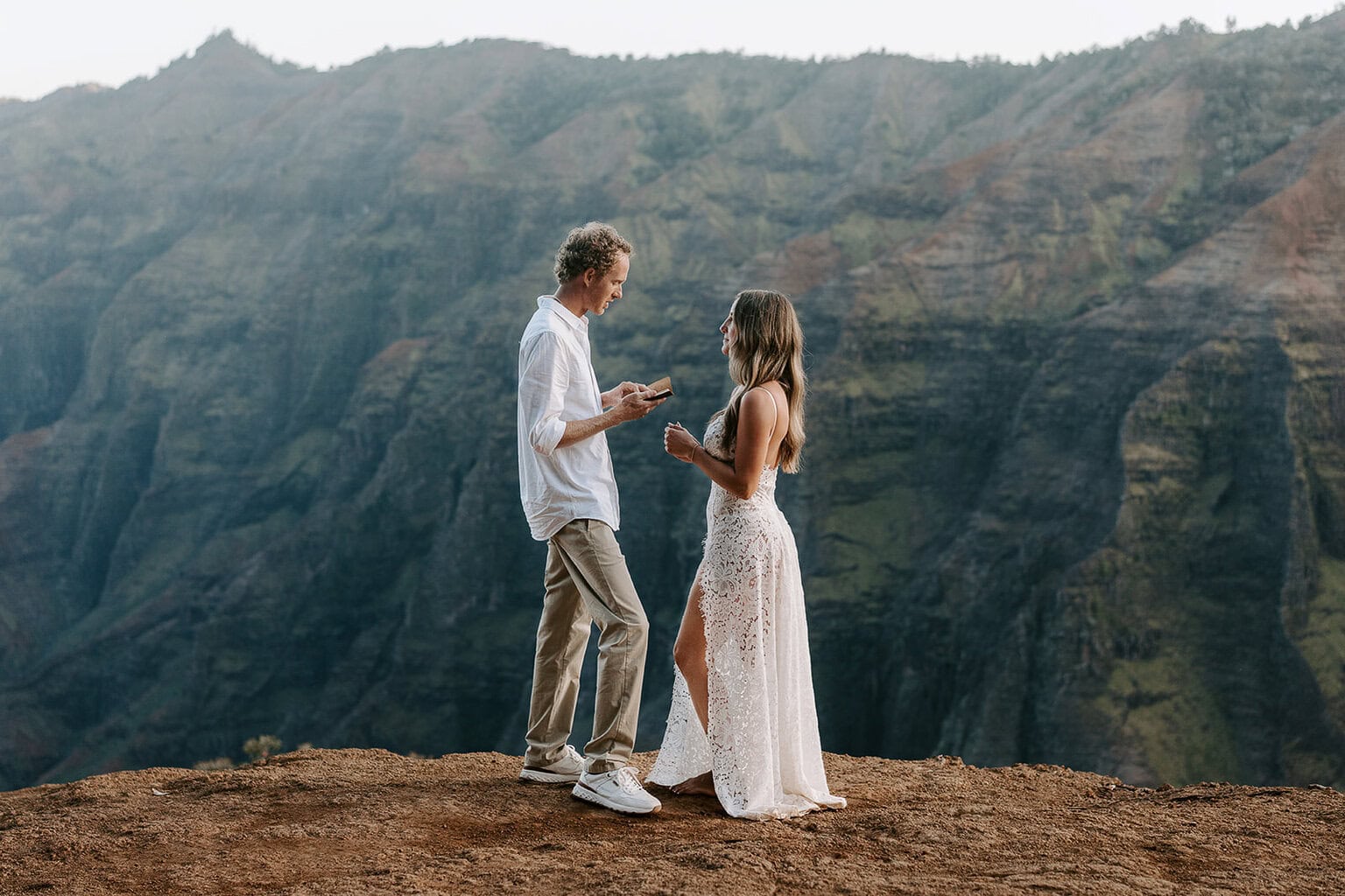 Newlyweds exchanging views above waimea canyon on kauai as they elope in Hawaii.