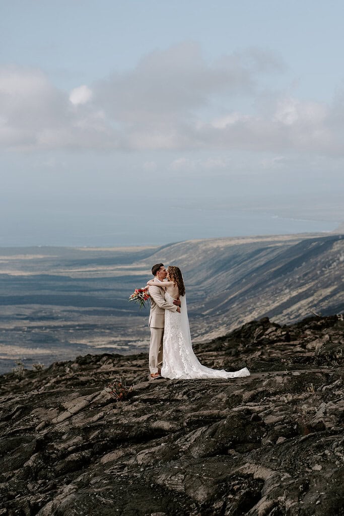 Newlyweds hugging in volcano national park as they elope in Hawaii.