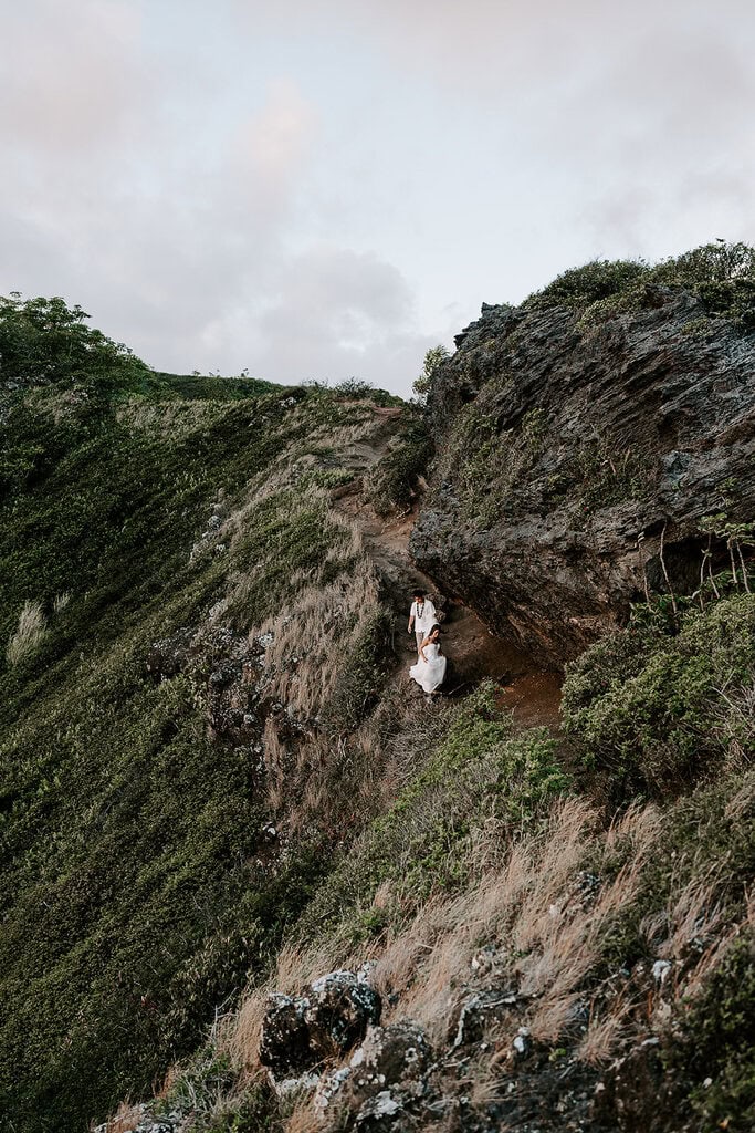 newlyweds hiking along a mountain during their Oahu elopement.