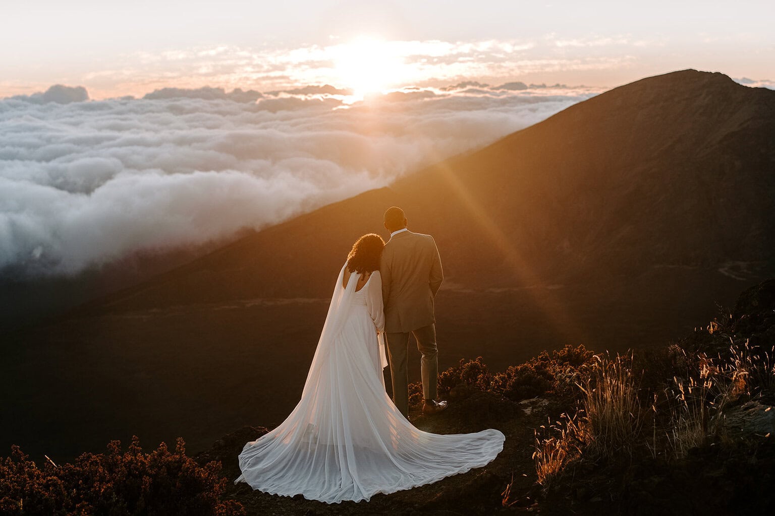 newlyweds taking in a sunrise on top of Haleakala.