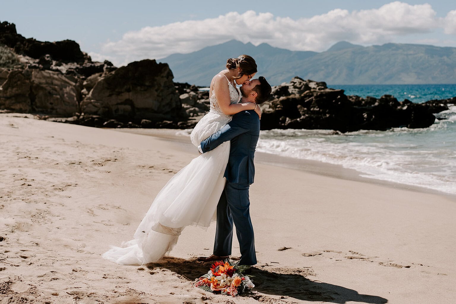 newlyweds hugging on the beach during their Maui elopement.