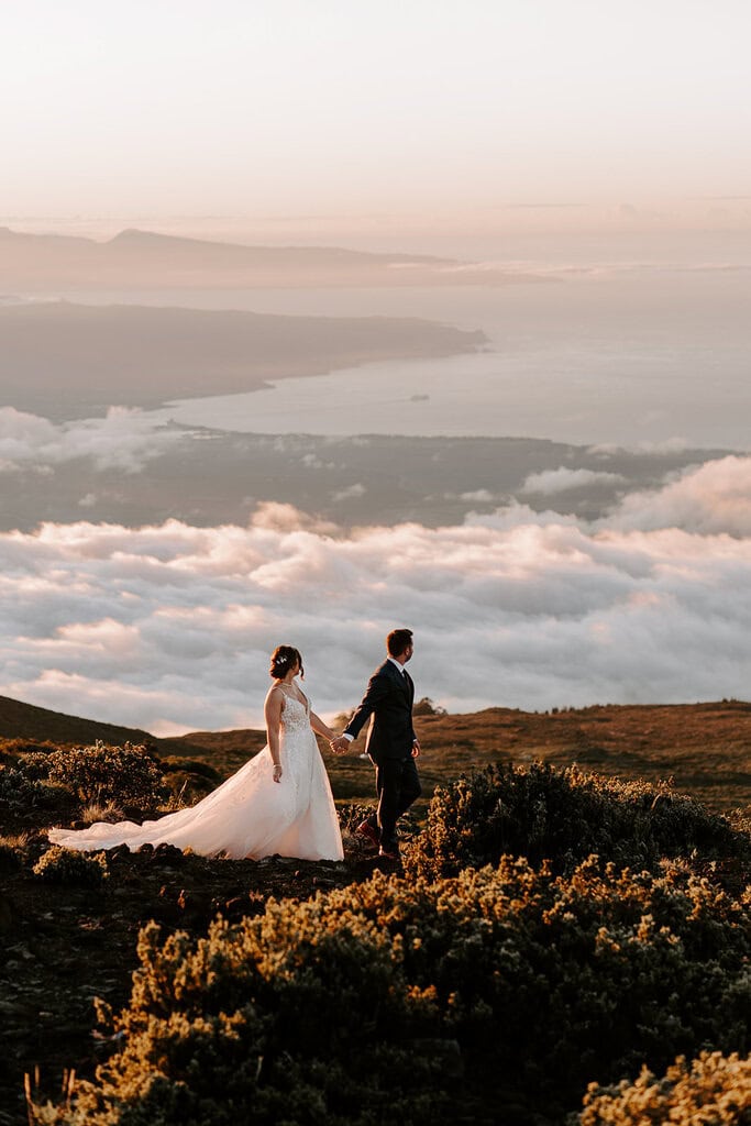 newlyweds holding hands above the cloud during their Maui elopement.