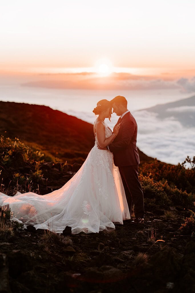 newlyweds hugging at sunset above the cloud during their Maui elopement.
