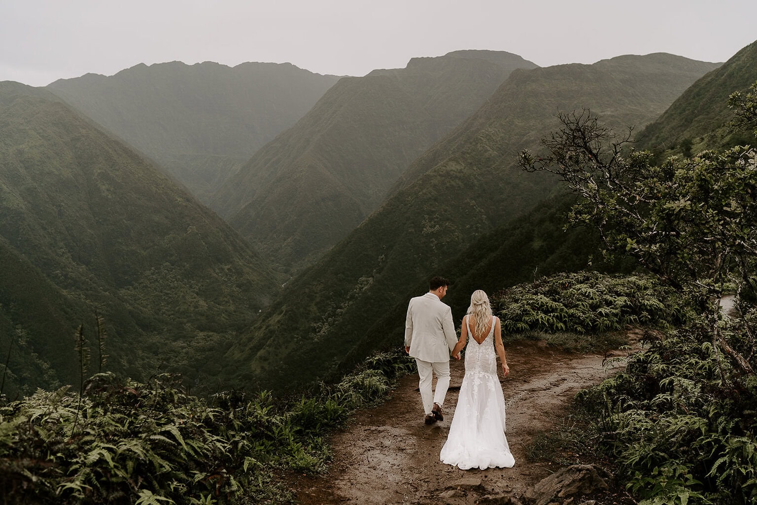 newlyweds hiking along a mountain trail during their Maui elopement.