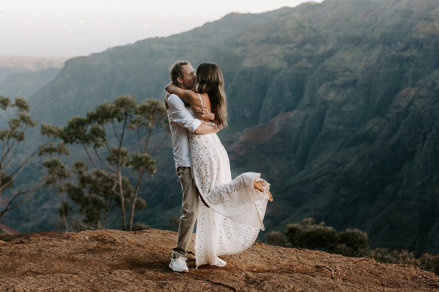 newlyweds kissing at waimea canyon during their kauai elopement.