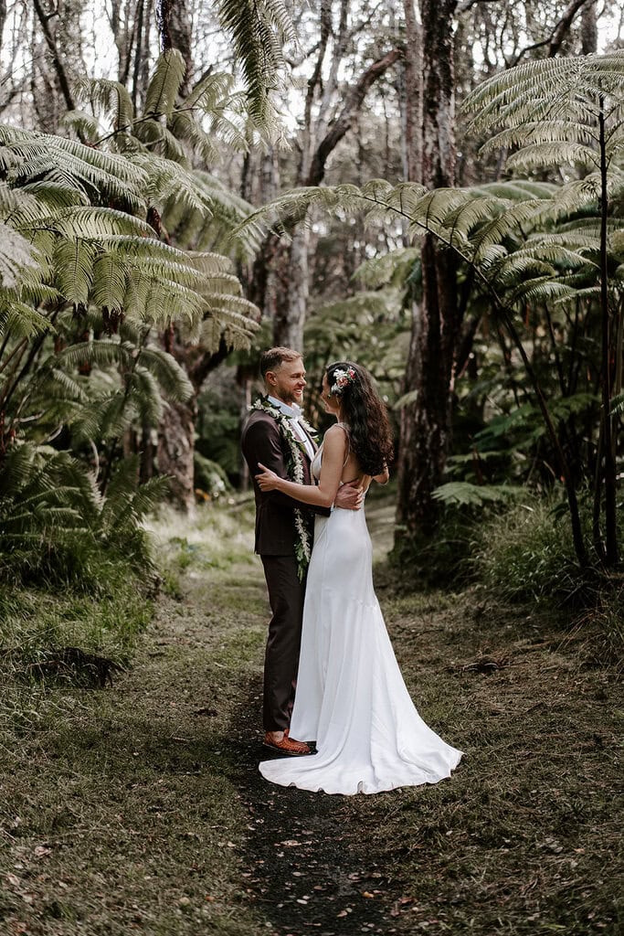 newlyweds hugging in a jungle in Hawaii.