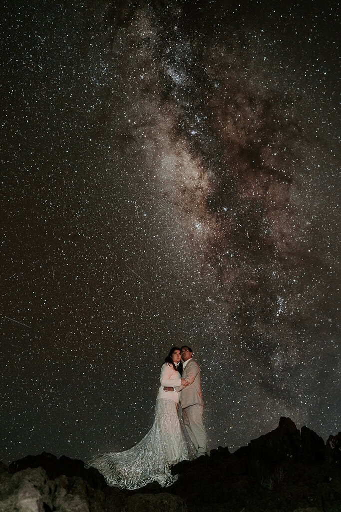 newlyweds hugging under the milky way.