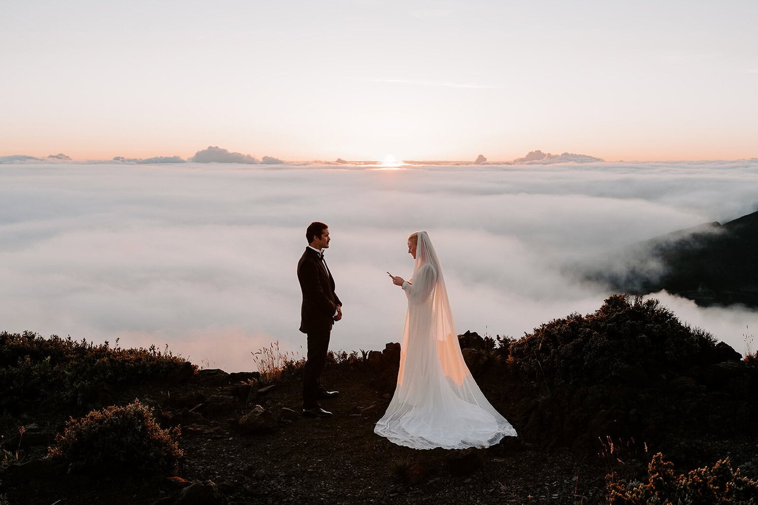 newlyweds exchanging vows at sunset during their Haleakalā wedding.