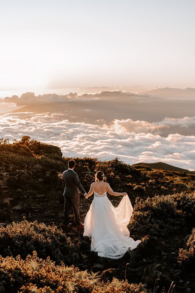 newlyweds walking down the side of Haleakalā during their wedding.