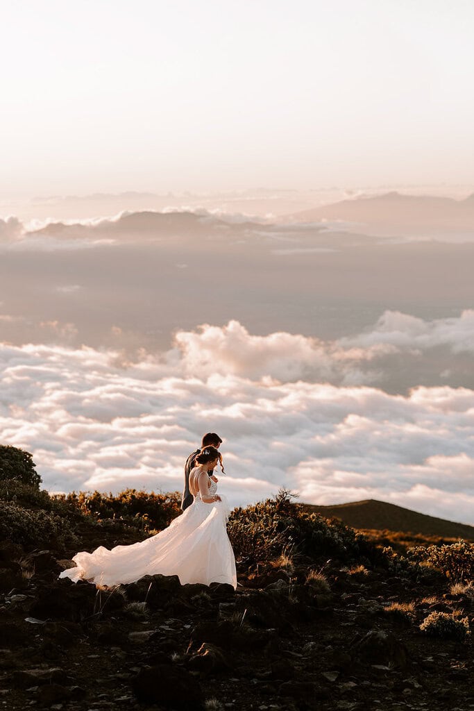 newlyweds walking above the clouds during their Haleakalā wedding.