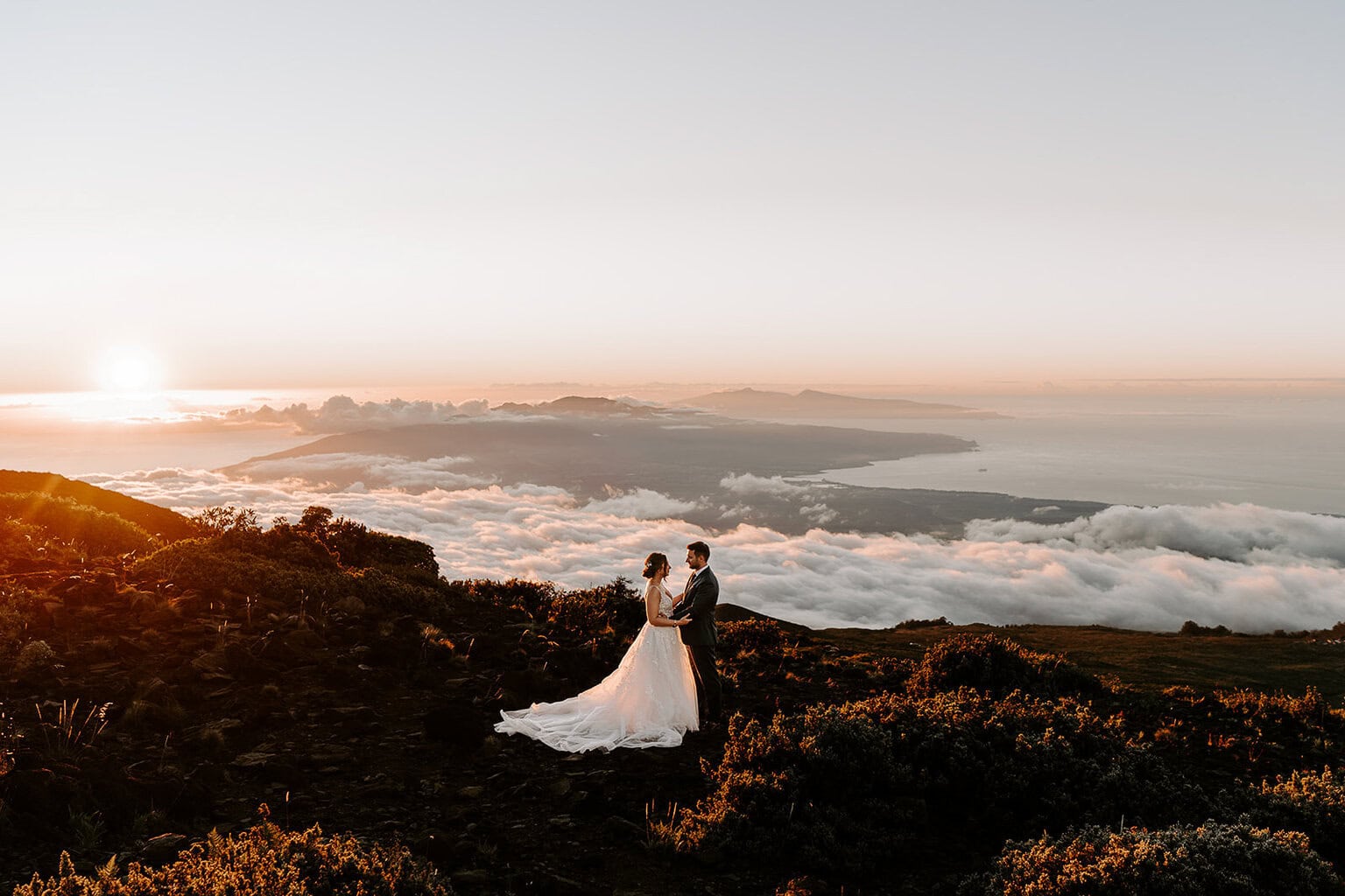 newlyweds hugging above the clouds during their Haleakalā wedding.