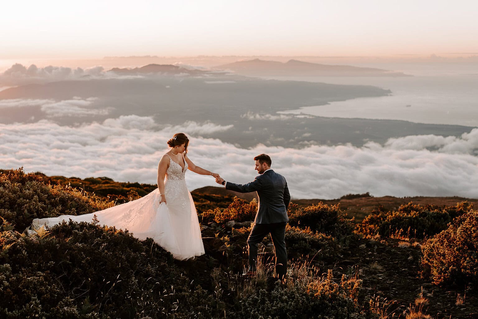 newlyweds walking along the side of Haleakalā during their wedding.