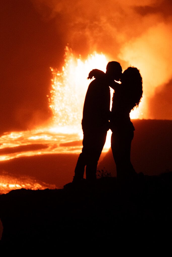 couple kissing in front of an active volcano in Hawaii Volcanoes National Park, one of the best places to get married on the Big Island.