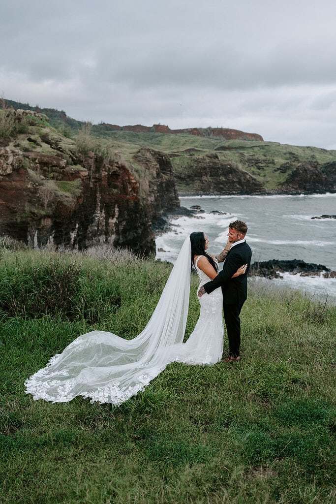 newlyweds hugging by the ocean cliffs in Maui.