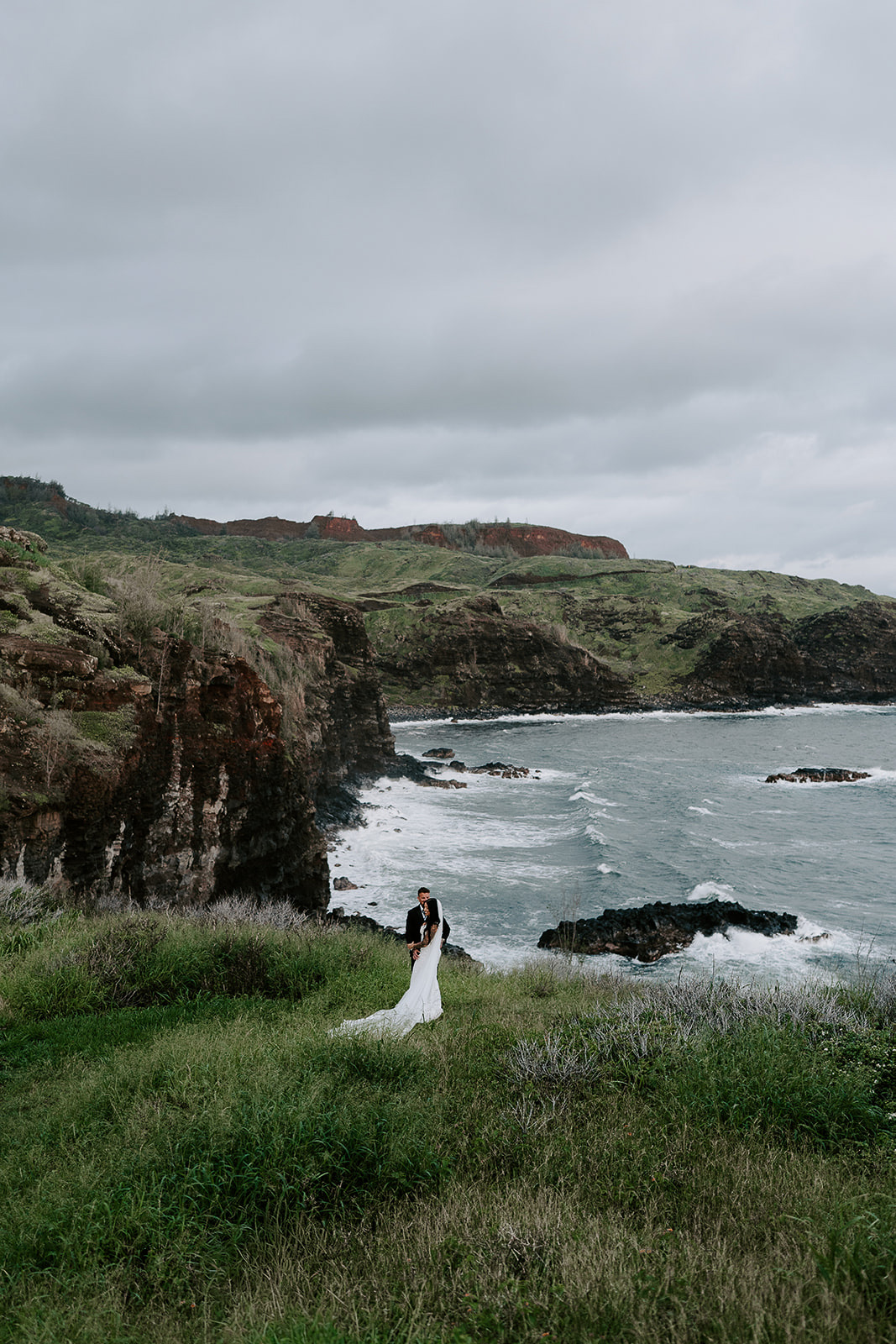 Newlyweds standing by the edge of a cliff in Maui, one of the best Maui elopement locations.