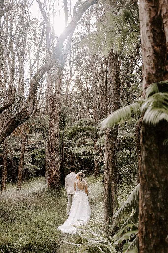 newlyweds hiking through the jungle in hawaii.