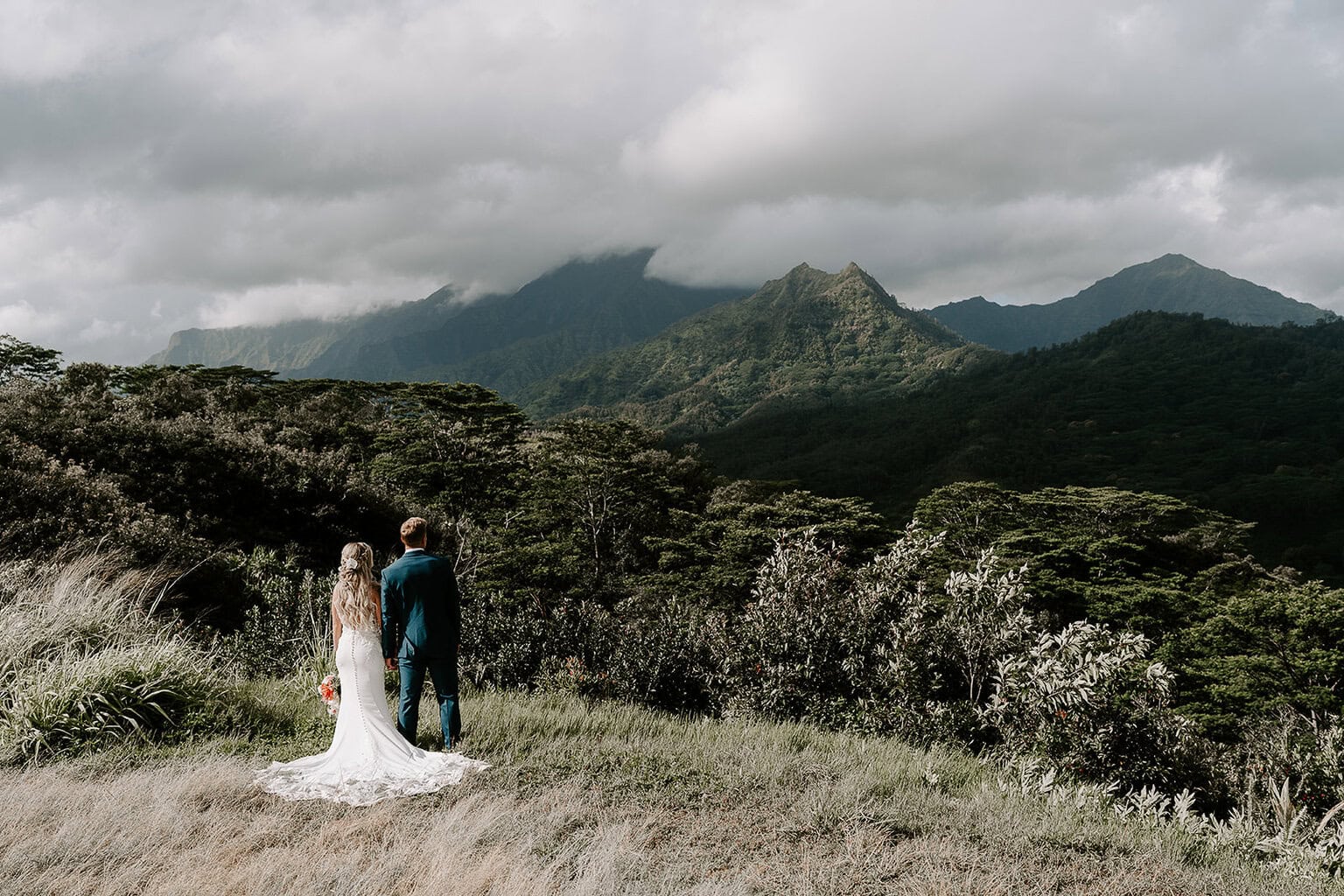 Newlyweds soaking in views of green mountains in Kauai.
