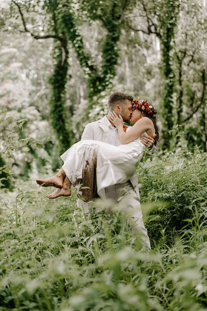 Newlyweds kissing in a lush jungle, one of the best Kauai elopement locations.